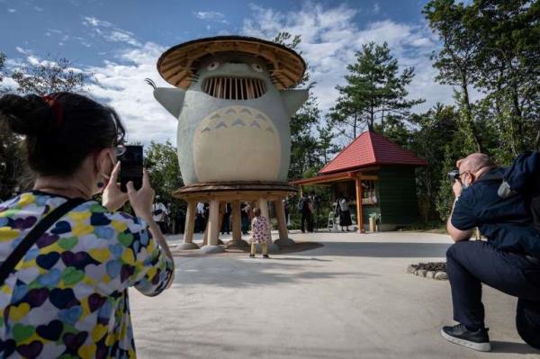 People taking photos of Ghibli characters at the new theme park ba<em></em>sed on the animation studio's films