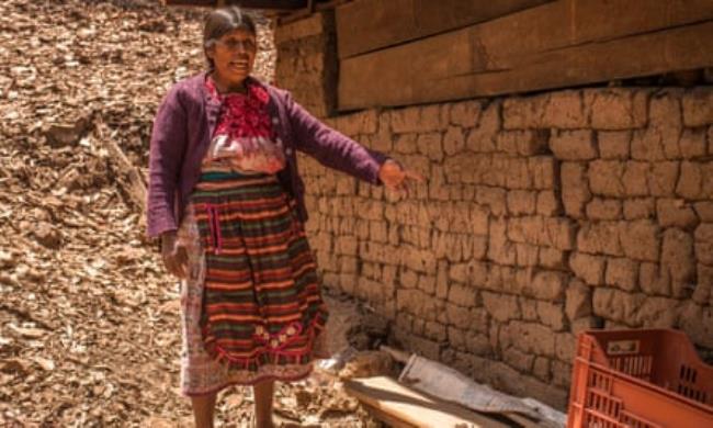 Patrocinia Mejía points to a crack in a wall of her house 