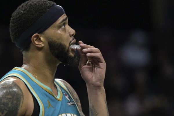 Charlotte Hornets forward Miles Bridges adjusts his mouth guard during the first half of an NBA basketball game against the Indiana Pacers, Sunday, Feb. 4, 2024, in Charlotte, N.C. (AP Photo/Matt Kelley)